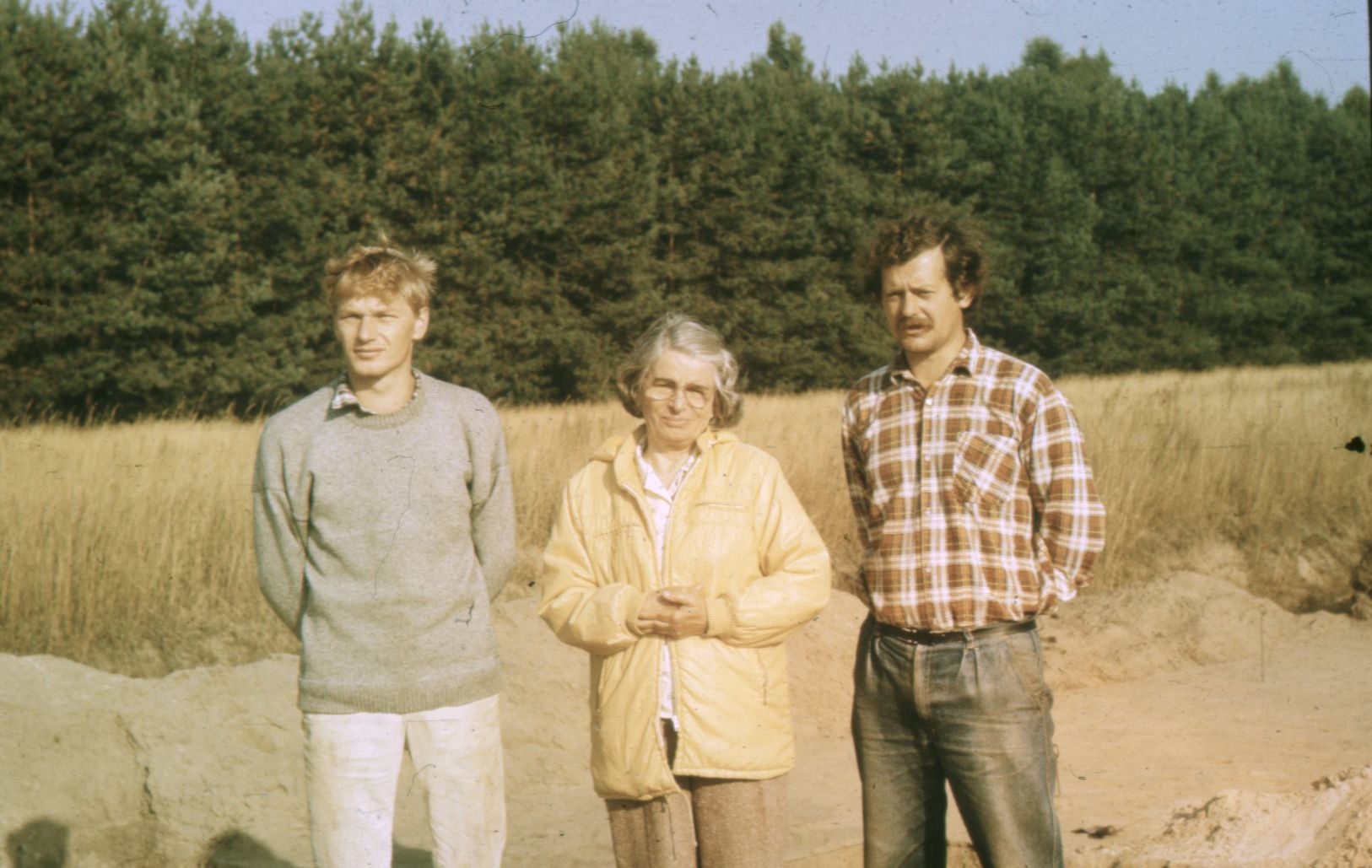 od lewej dr Piotr Papiernik, Eleonora Kaszewska i dr Wojciech Siciński, zdjęcie wykonane podczas badań archeologicznych, w tle ściana lasu